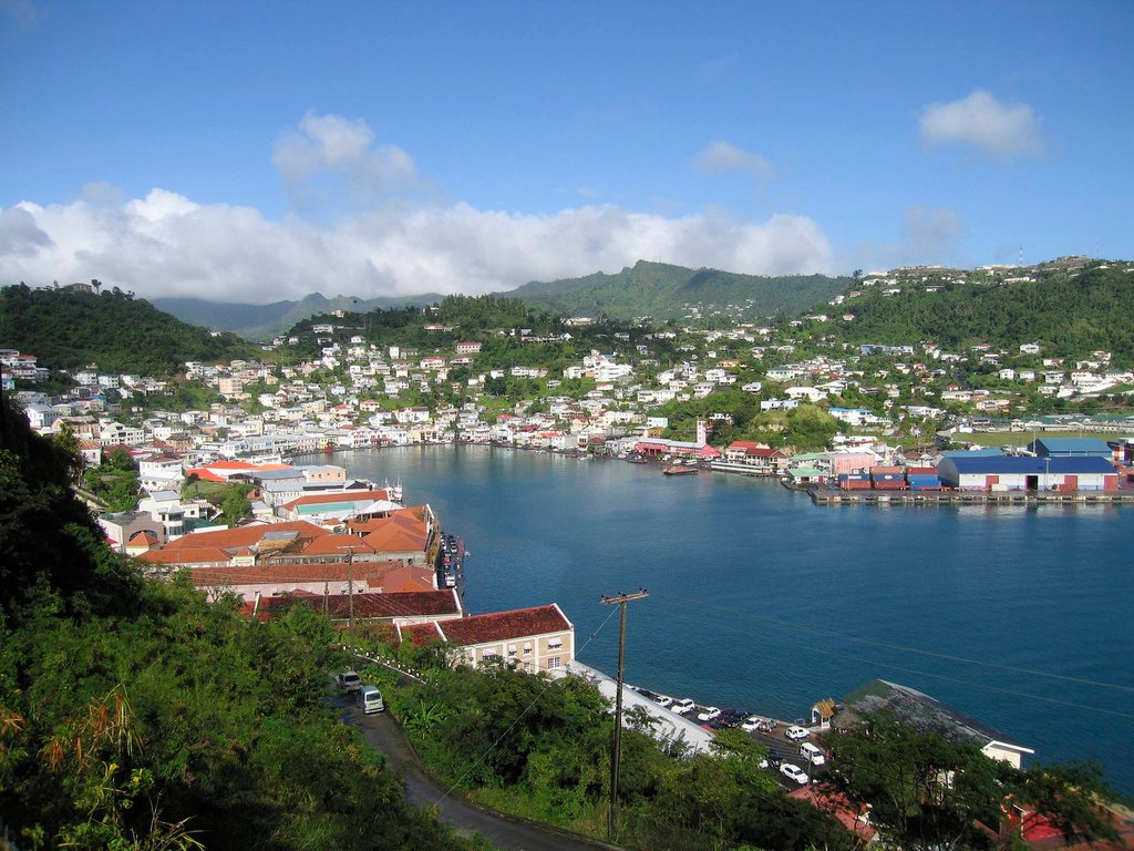 Panoramic view of Saint George's harbour in Grenada, showing the horseshoe bay with colourful buildings climbing the hillside and boats moored in the water