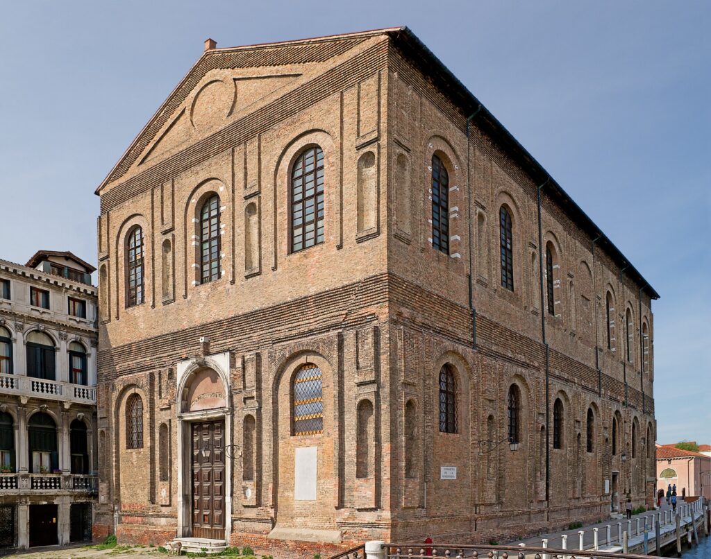 The bare brick bulk of the Scuola Nuova della Misericordia, whose marble facing was never added