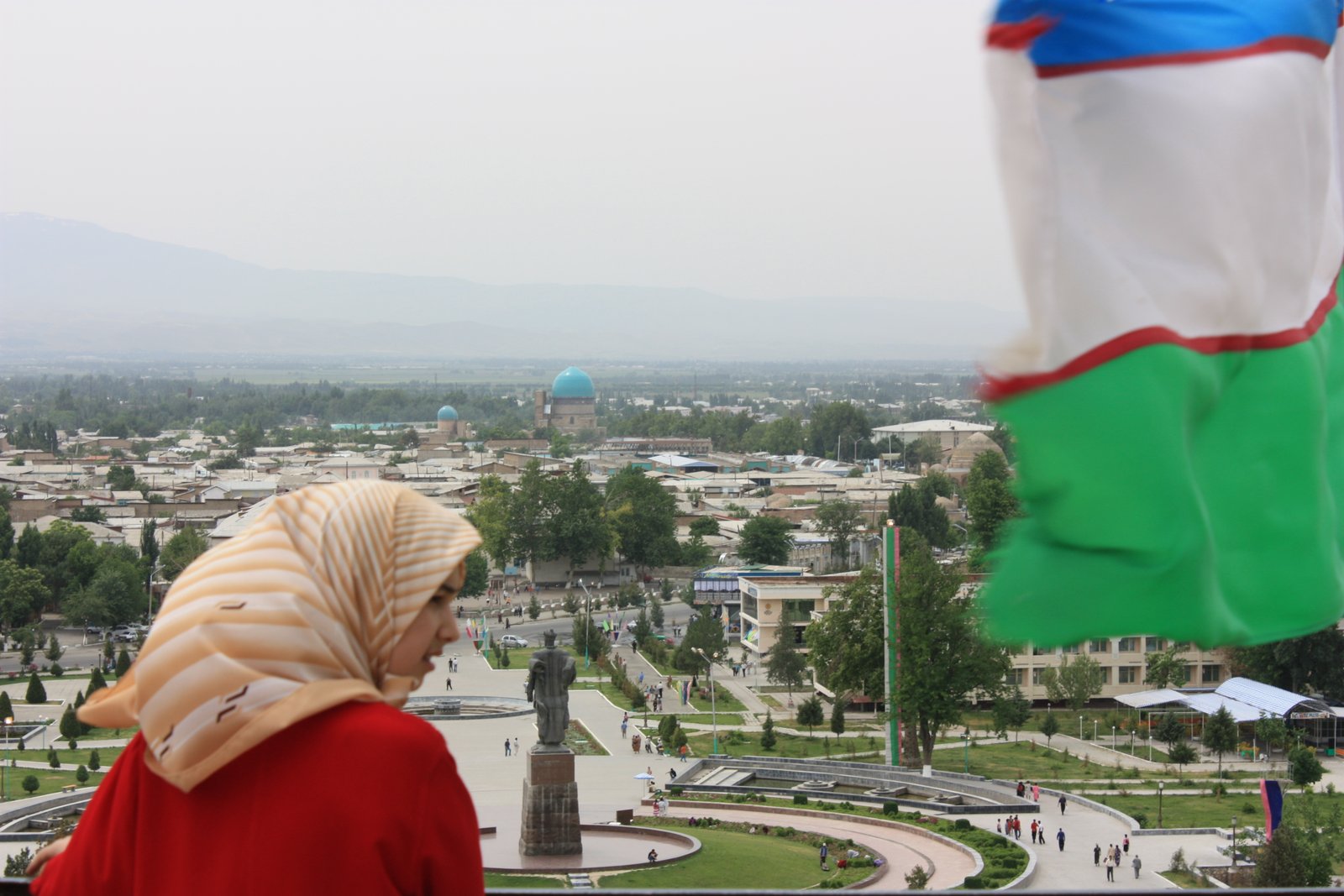 Massive portal arch ruins of Ak-Saray palace rising above Shakhrisabz with mountains behind