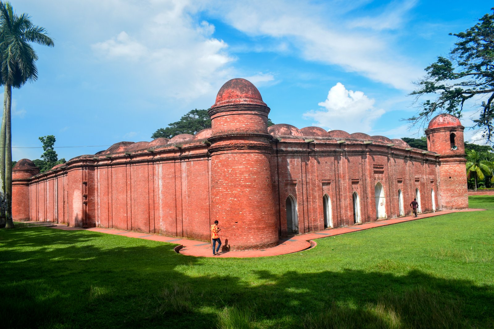 Exterior view of the Sixty Dome Mosque at Bagerhat, Bangladesh, under blue sky