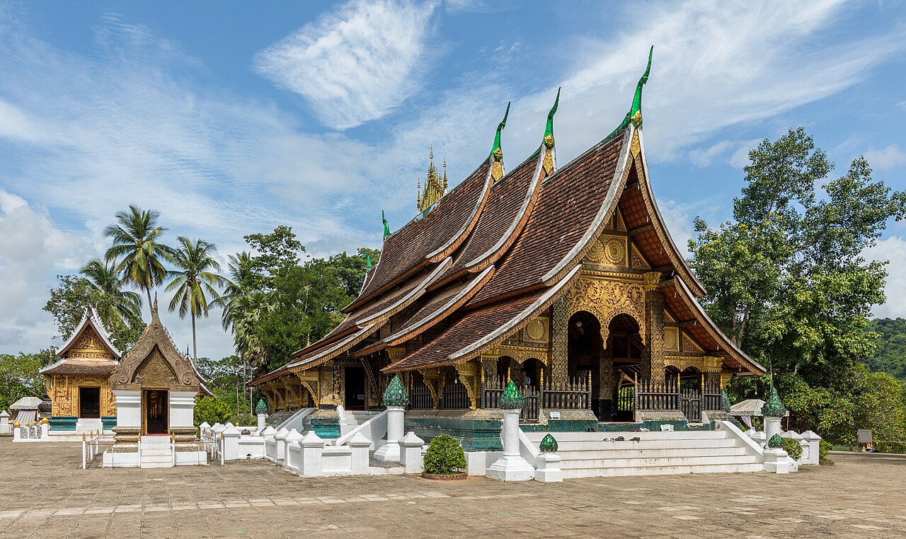 Wat Xieng Thong temple sweeping tiered roofline and gilded exterior in Luang Prabang