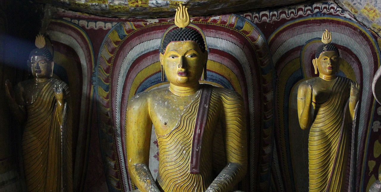 Three large gilded Buddha statues inside Dambulla cave temple, Sri Lanka