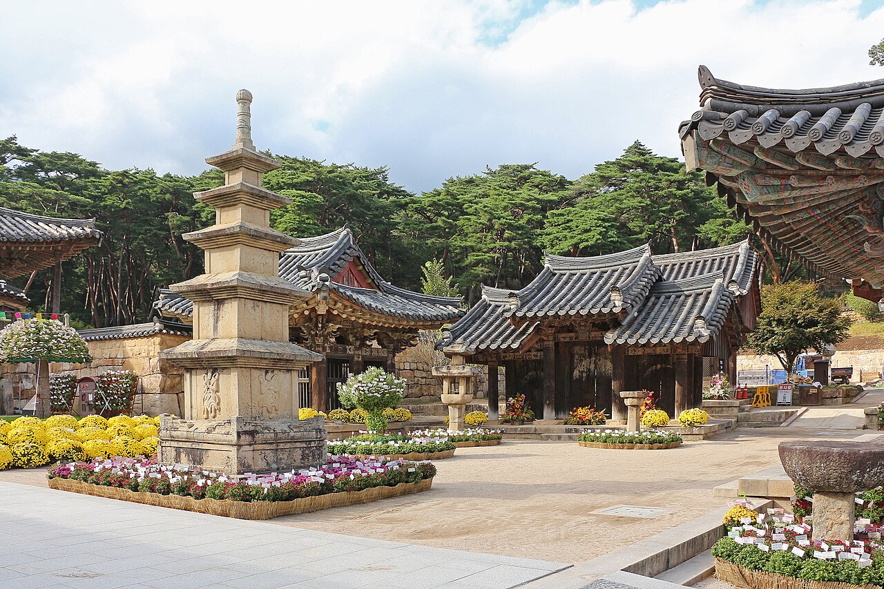 The main ceremonial approach path through the ancient pine forest to Tongdosa Temple, South Gyeongsang Province, South Korea — the largest of the seven Sansa Buddhist mountain monasteries inscribed as UNESCO World Heritage in 2018, founded circa 646 CE and containing no Buddha hall with a Buddha image