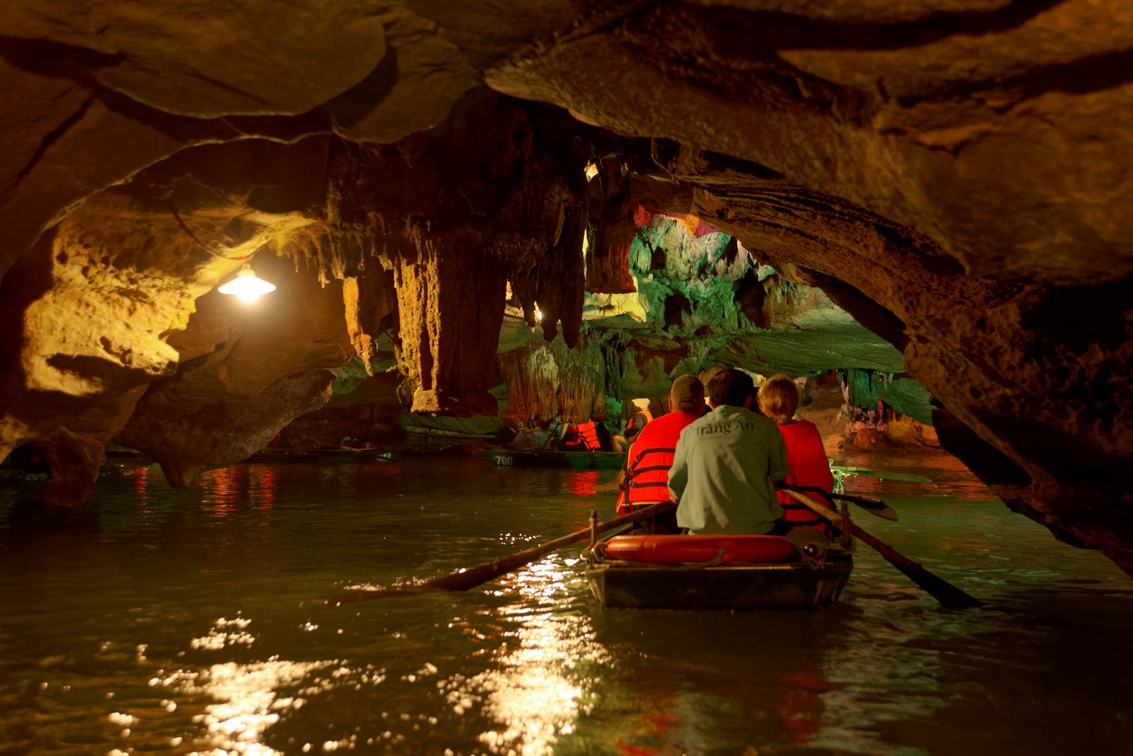 Sampan boats passing through limestone karst passages at Trang An Ninh Binh Vietnam