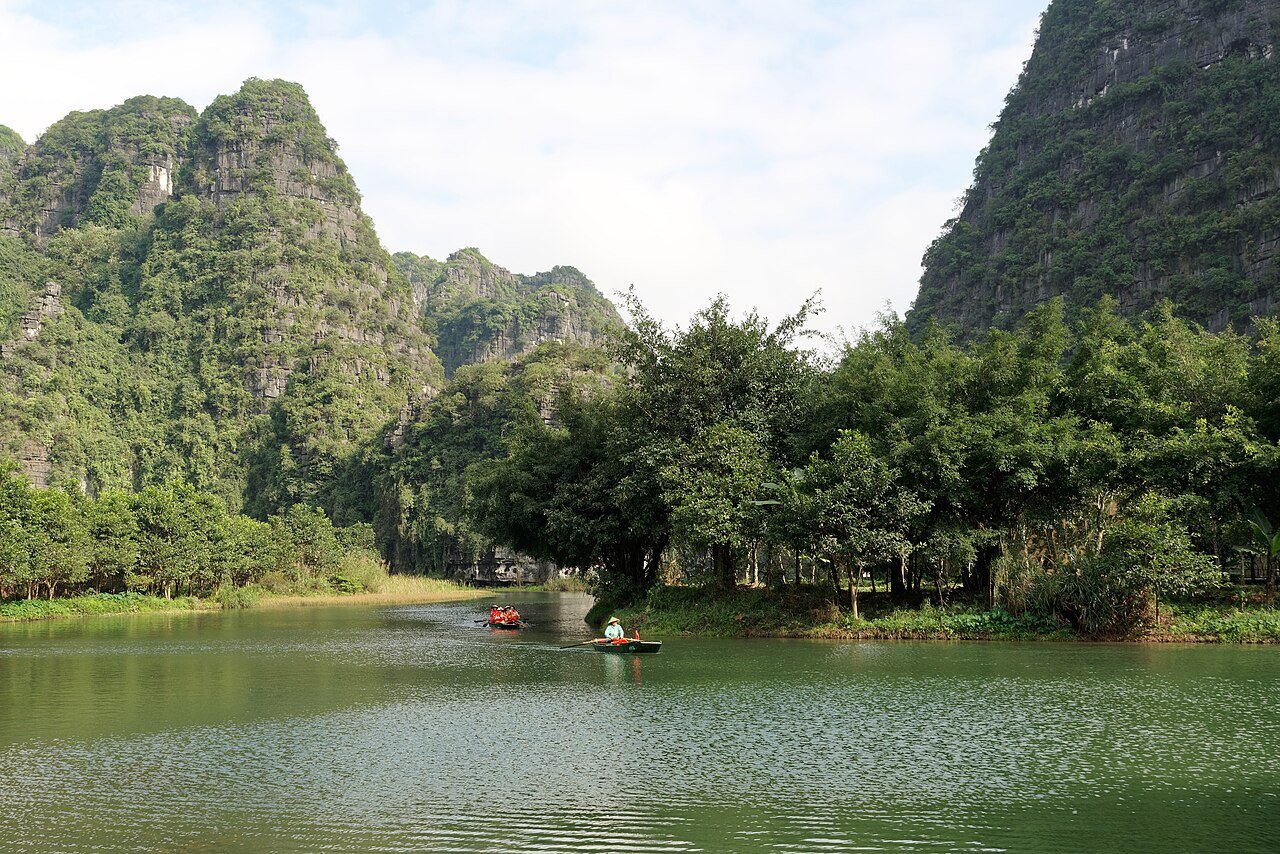 Limestone karst mountains rising from flooded valleys at Tràng An Scenic Landscape Complex, Ninh Binh, Vietnam