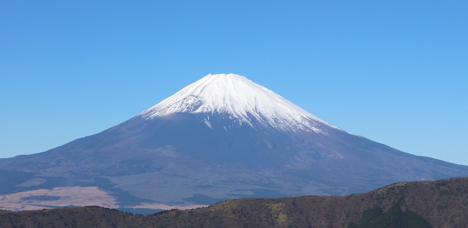 Snow-capped summit cone of Mount Fuji seen from Ōwakudani in winter