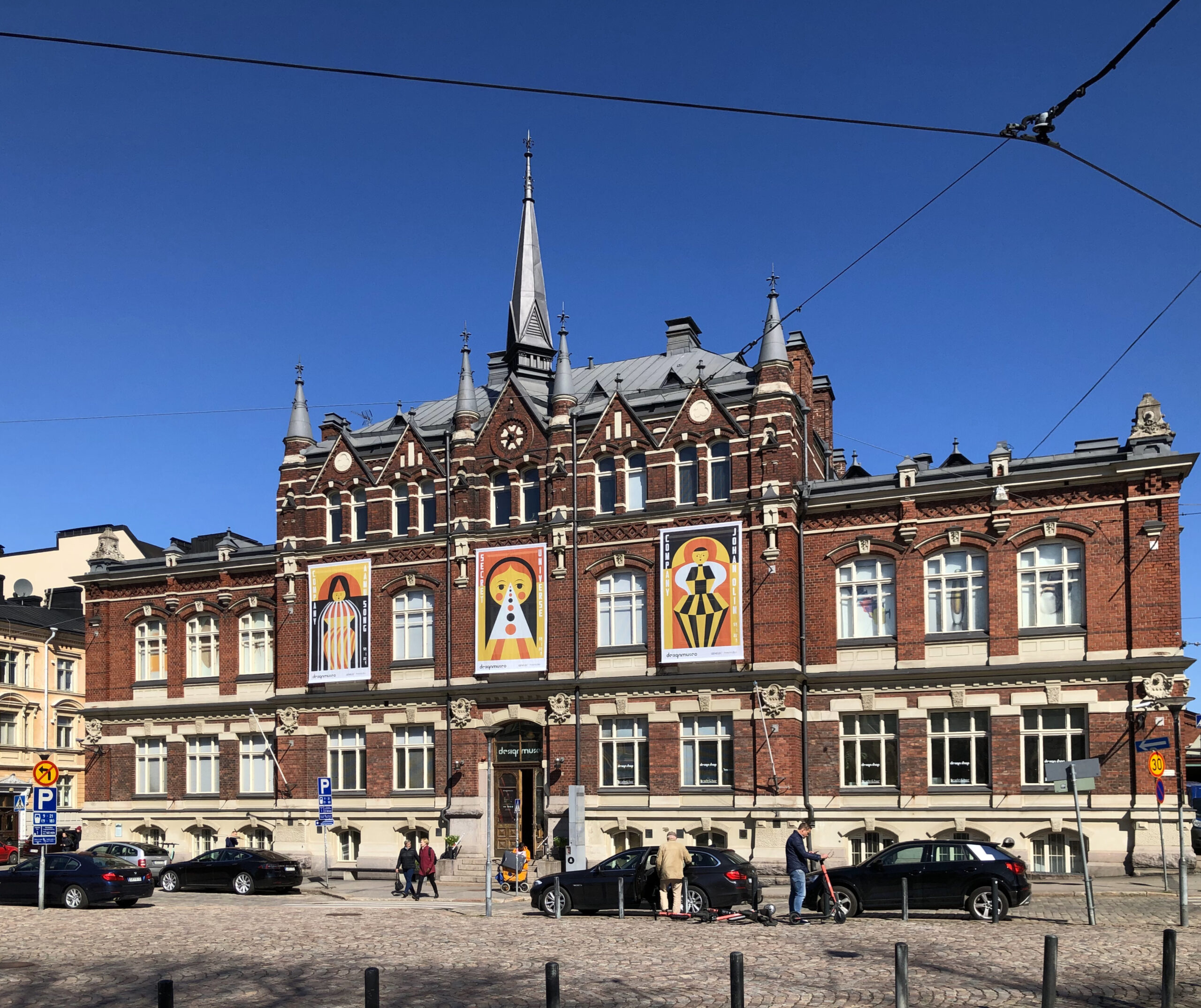 The red brick neo-Gothic facade of the Architecture and Design Museum in Helsinki with exhibition banners