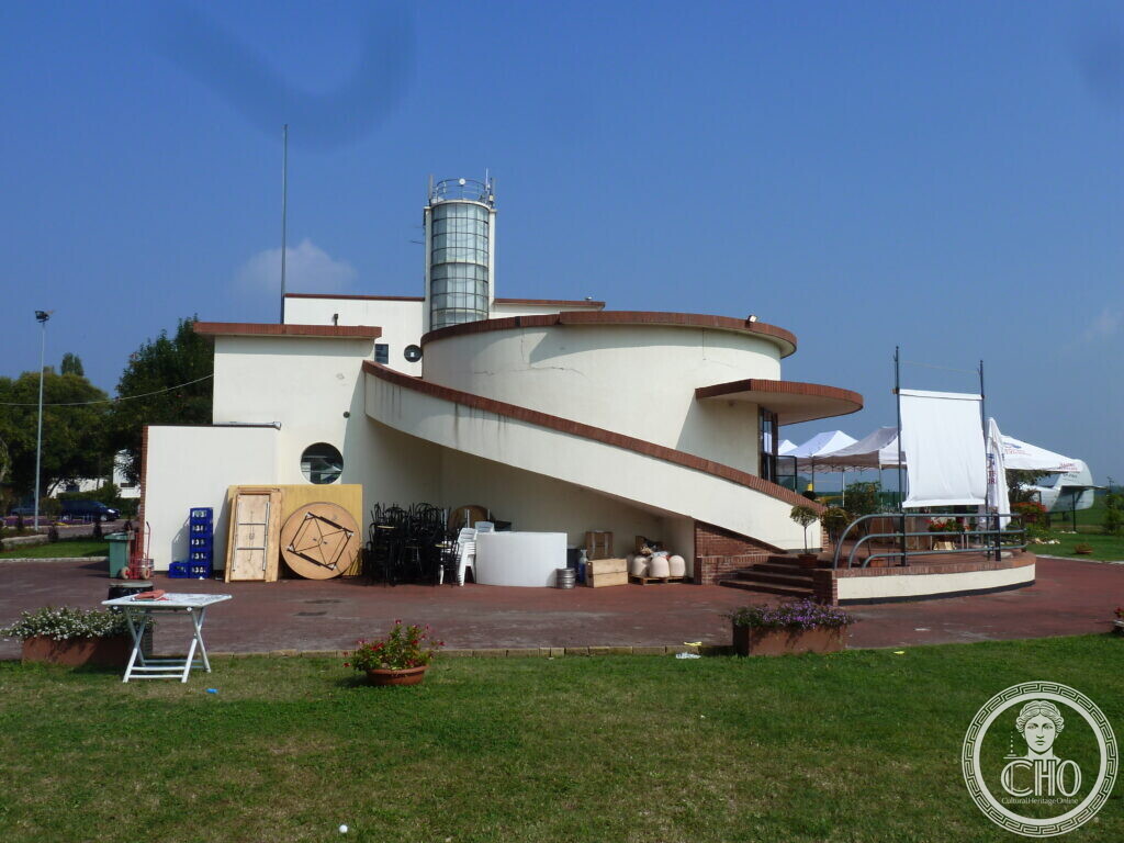 The curved brick ramp and staircase wrapping around the cylindrical control tower of Nicelli airport terminal