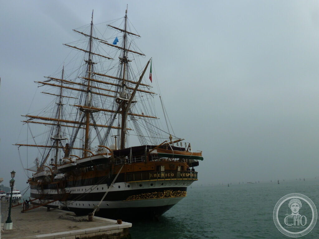 The training ship Amerigo Vespucci moored at a quay in Venice, three masts against a misty lagoon