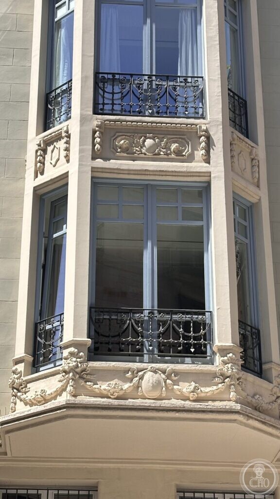 A narrow building in the old city with five storeys of glazed bay window and carved garlands
