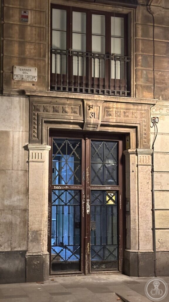 A stone doorway with a frieze of carved flowers and the number 31, beside a street plaque