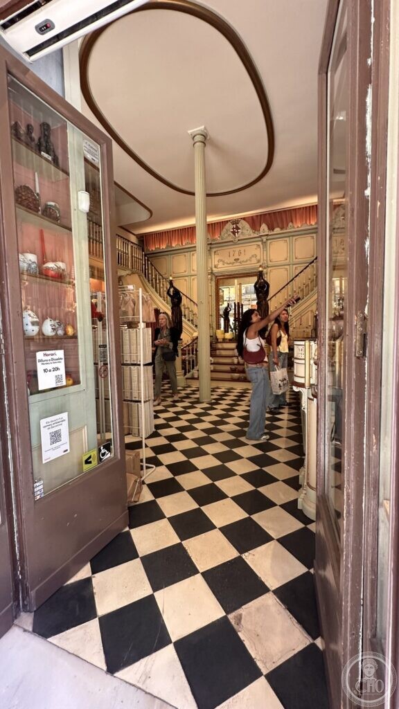 The interior of the candle shop with a chequered marble floor, cast-iron column and a dividing staircase