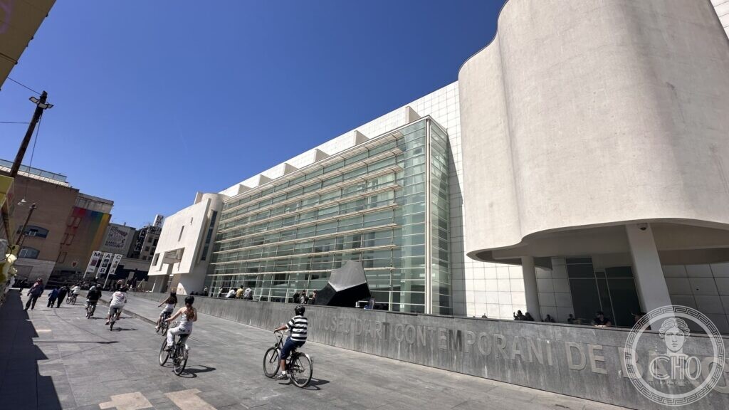 Richard Meier white facade of the MACBA on Placa dels Angels, with cyclists crossing the square