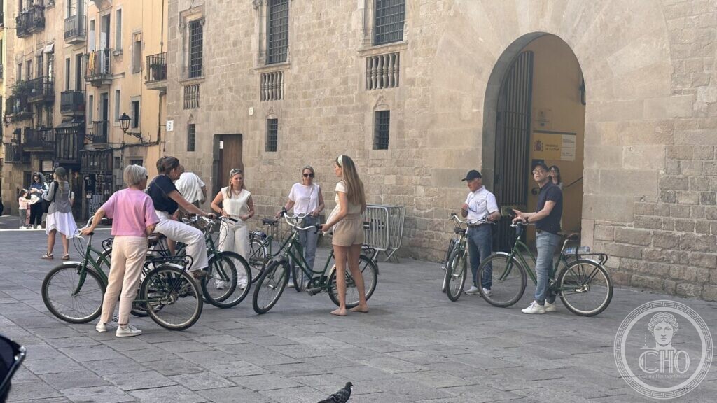 A group with hired bicycles standing in front of the great arched doorway of the palace