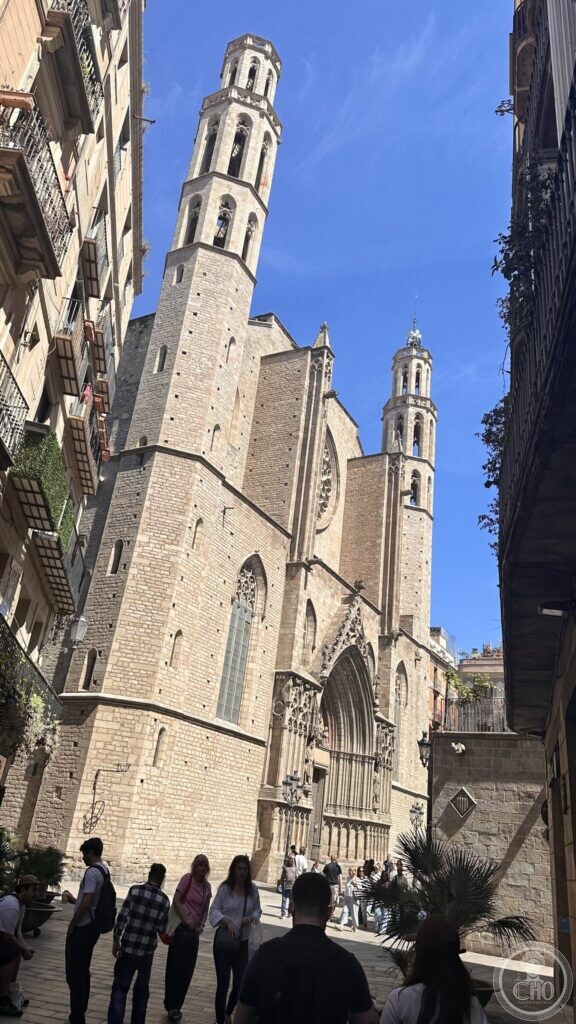 The two octagonal bell towers and main portal of Santa Maria del Mar seen up a narrow street