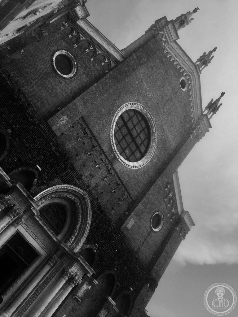 Soaring Gothic brick facade and grand rose window of the Basilica dei Santi Giovanni e Paolo in Venice
