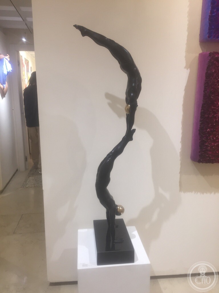 Tall dark figurative sculpture of a diving or reaching figure, on display at Bel-Air Fine Art, San Marco I, Venice