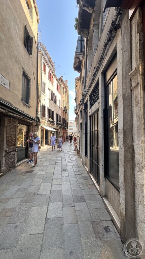 Narrow Venetian calle leading toward Campo Manin, lined with shops