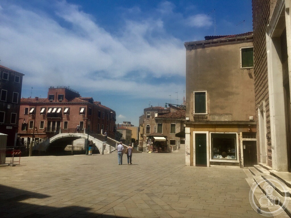 Wide view across Campo San Pantalon showing the brick facade of San Pantalon church and the arched Ponte San Pantalon in Venice