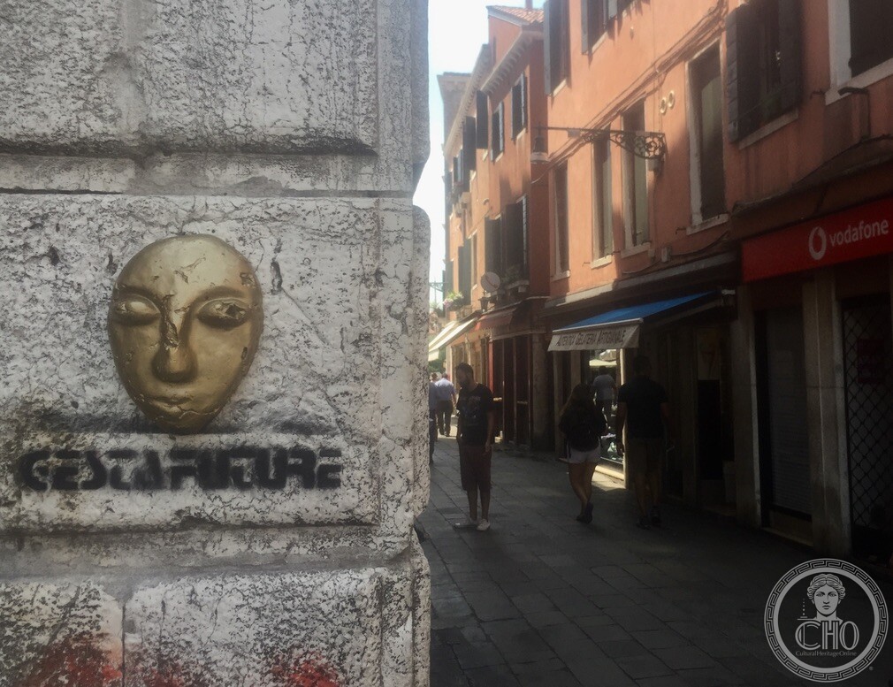 Sculpted golden mask and Cesta Future street art stencil on an Istrian stone corner pillar near Campo Santa Margherita