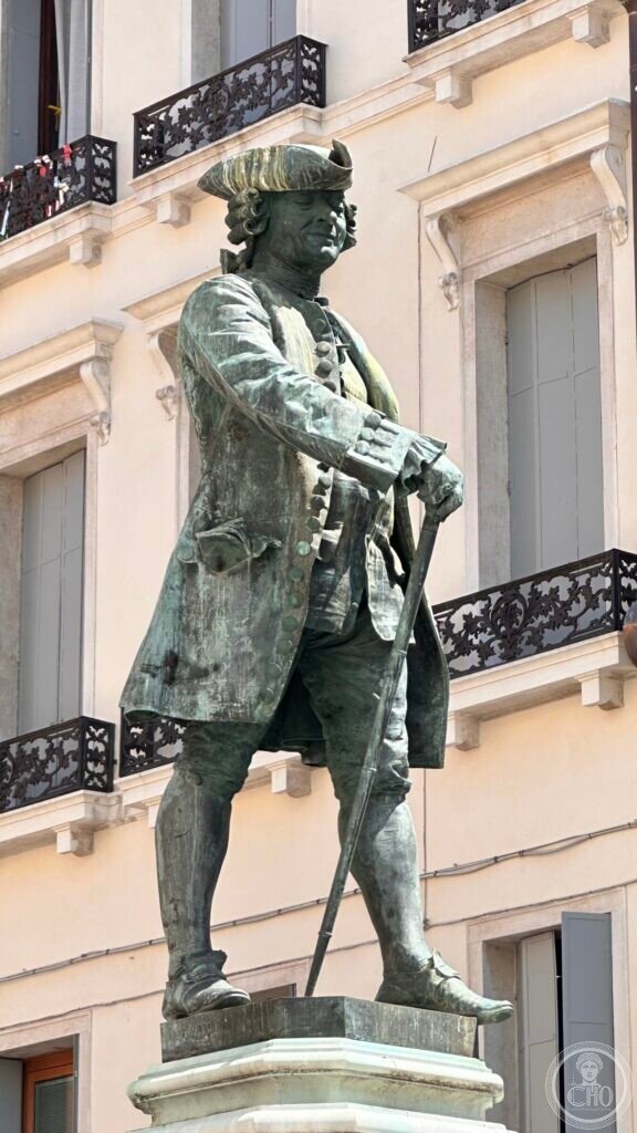 The full bronze figure of Goldoni in eighteenth-century dress with a walking stick, seen from below