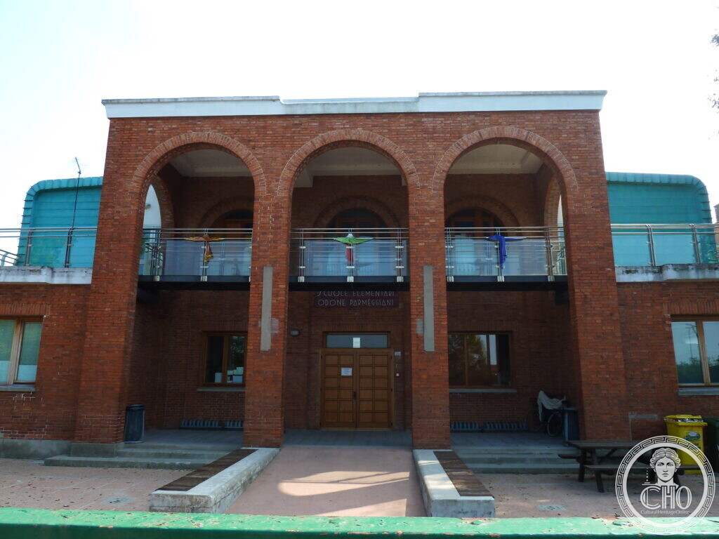 Close view of the triple-arched brick loggia, with the sign SCUOLE ELEMENTARI ODONE PARMEGGIANI