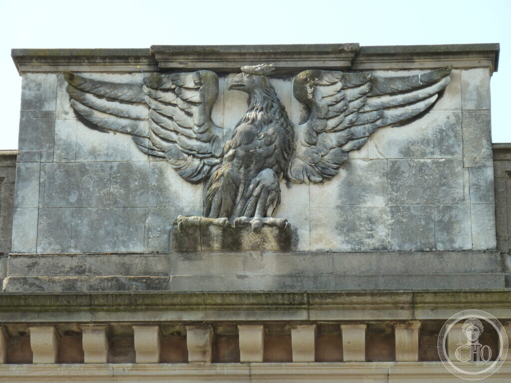 Close view of a carved stone eagle with spread wings on the building parapet