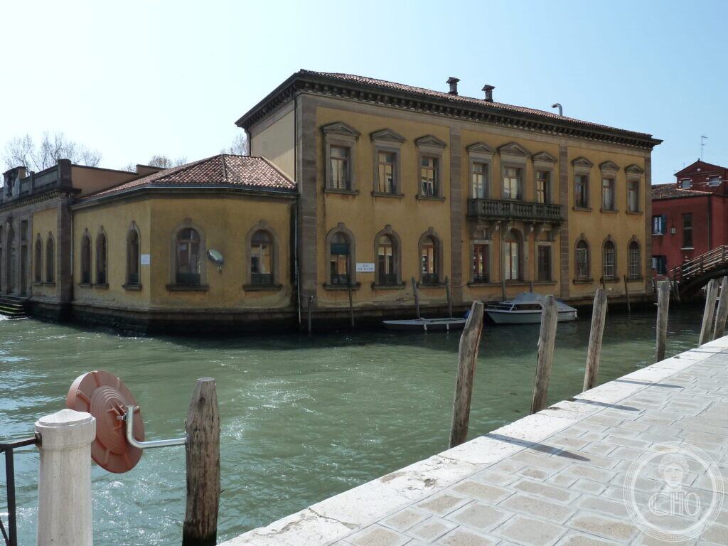 The former GIL house seen from across the canal, with mooring poles in the foreground