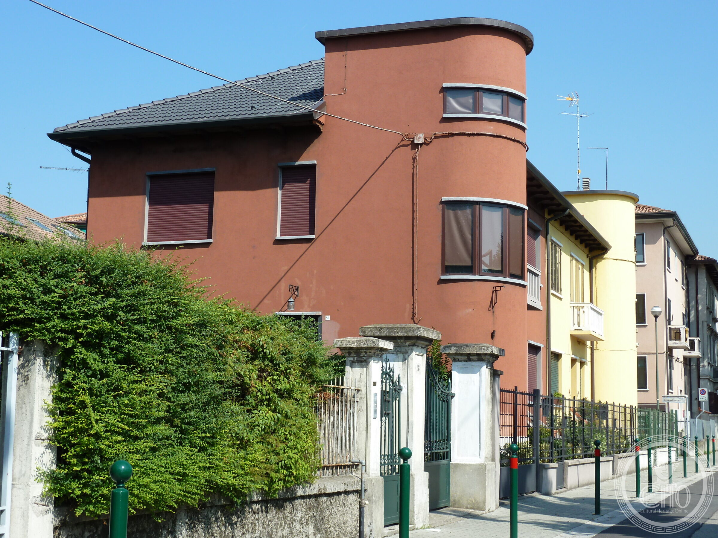 The dark red twin house in Marghera, with the same cylindrical stair tower