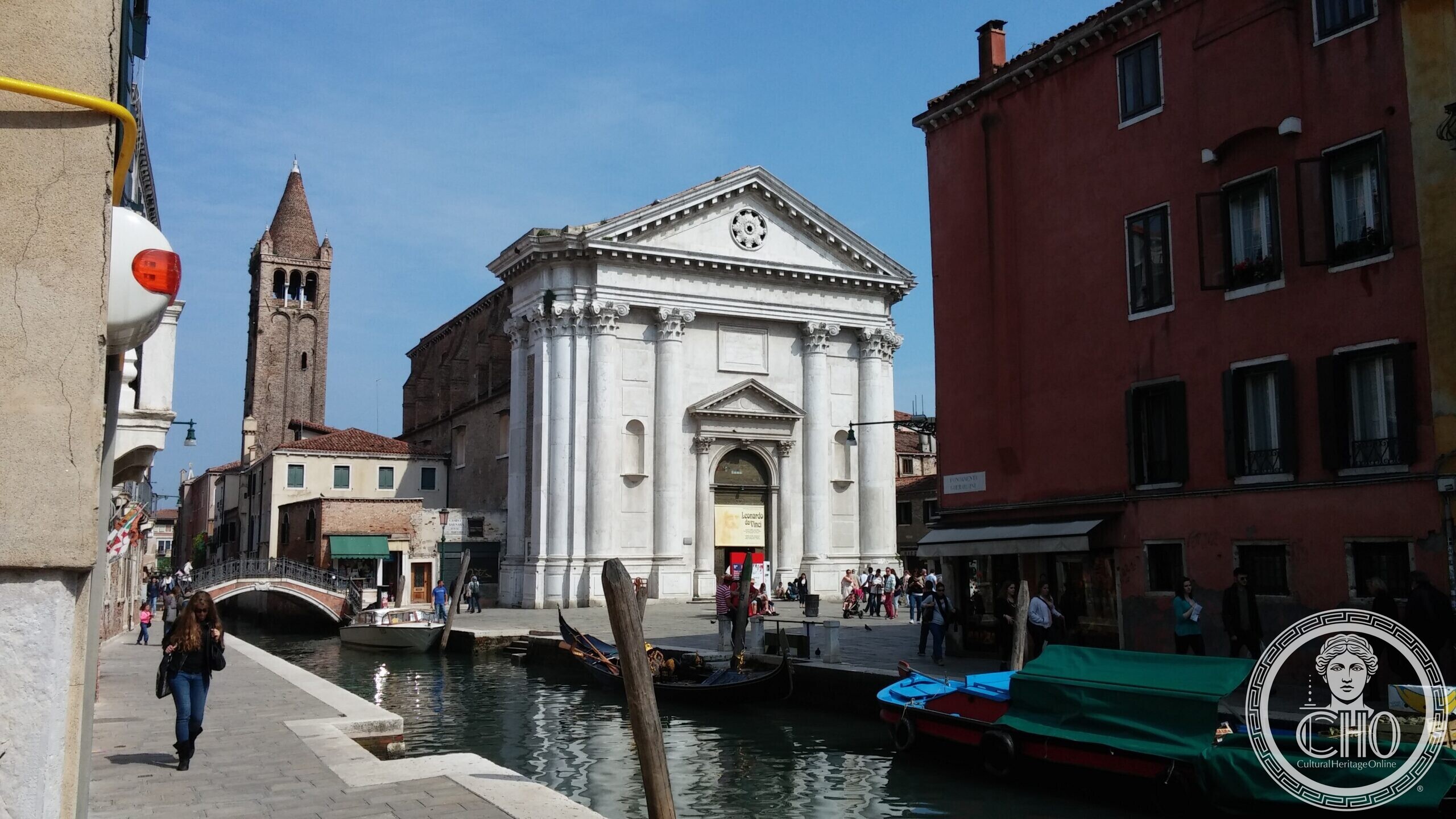 The church of San Barnaba and its brick campanile seen from the rio, with gondolas moored along the fondamenta