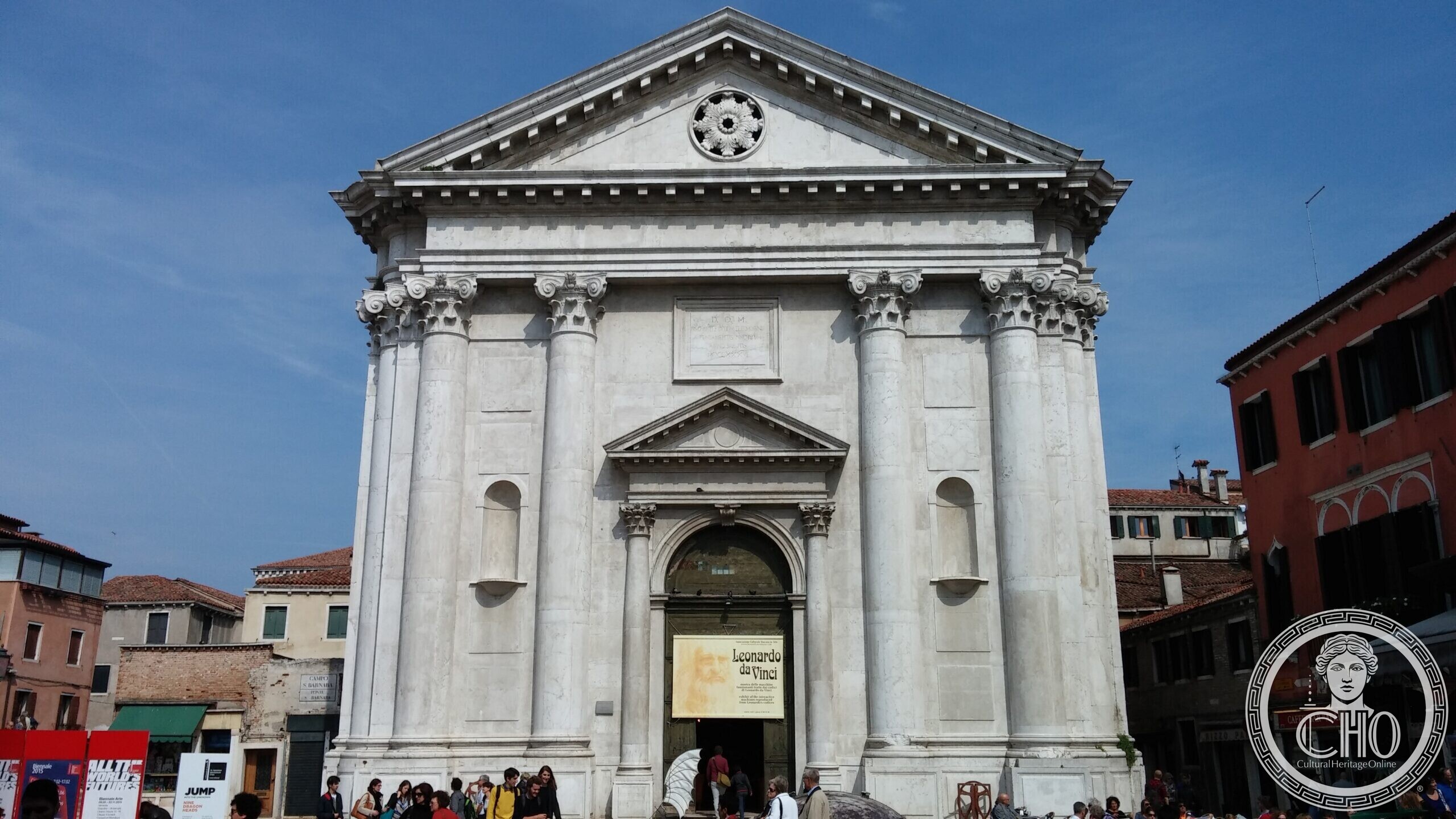 The classical facade of the church of San Barnaba in Venice, with an exhibition banner over the door