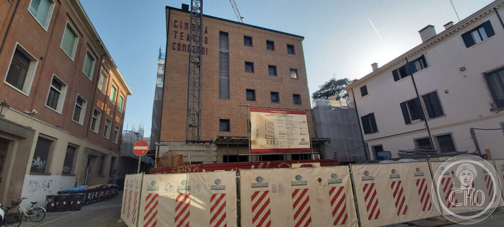 The front of the Cinema Teatro Concordi in Padua during the works, with the painted name on the brick and the municipal site board showing the conversion project