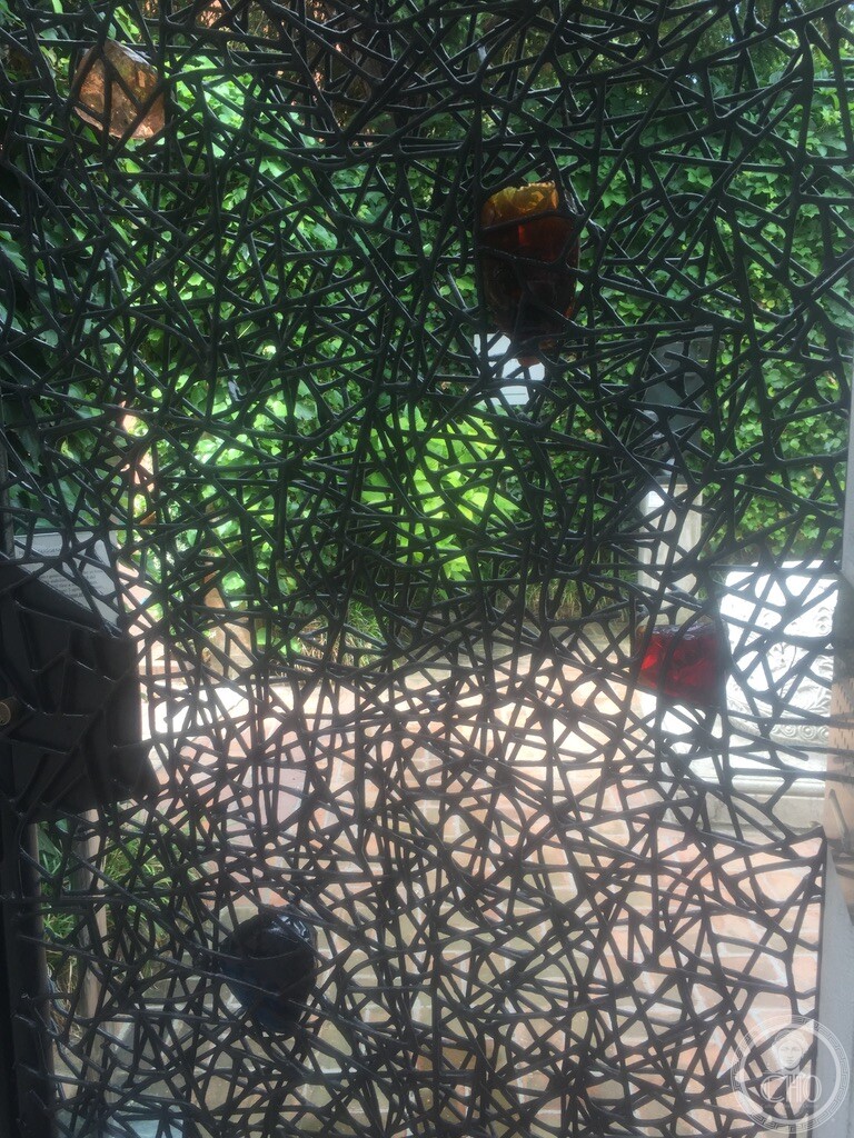 Detail of the web-like welded iron entrance gate designed by Claire Falkenstein in 1961 studded with coloured Murano glass chunks
