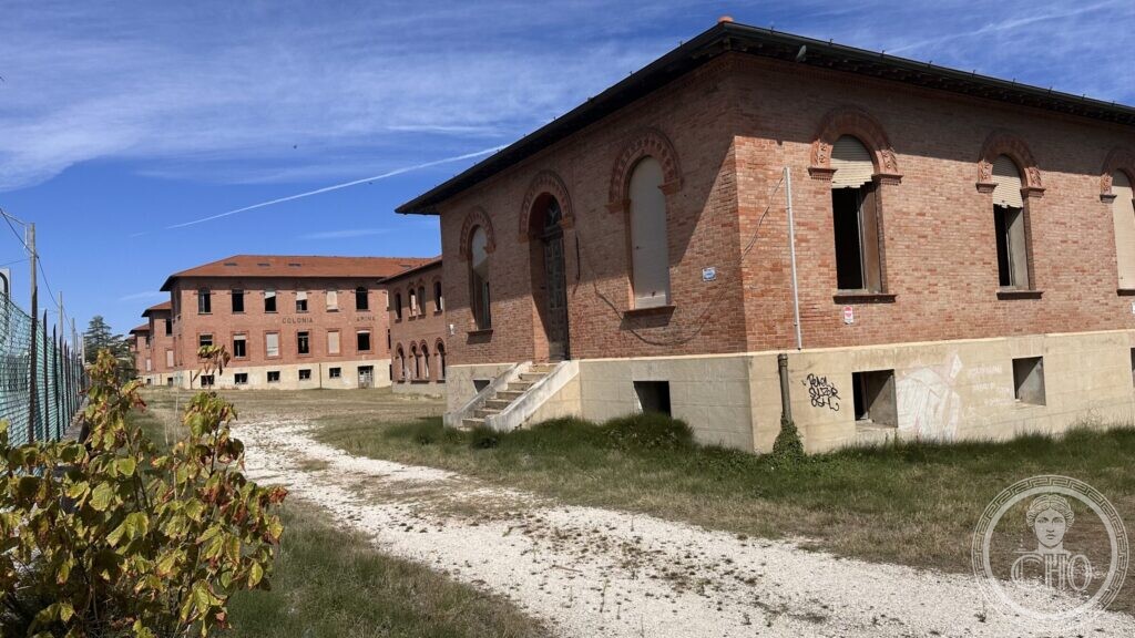 A gravel path running between the brick buildings of the colony