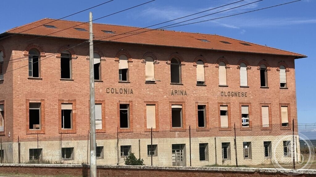The brick front of the colony with the raised letters COLONIA MARINA BOLOGNESE, two initials missing