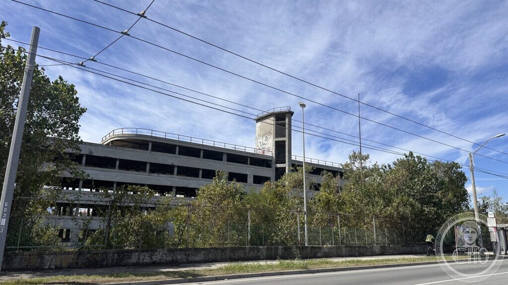 The Colonia Novarese behind a perimeter fence, seen from the road with overhead trolleybus wires
