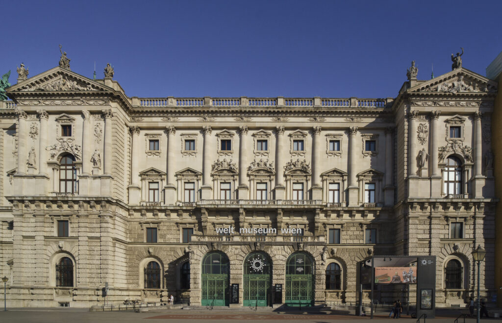 Historicist palace front of the Corps de Logis with statues on the roofline, Corinthian pilasters and three arched green gates under the lettering welt museum wien