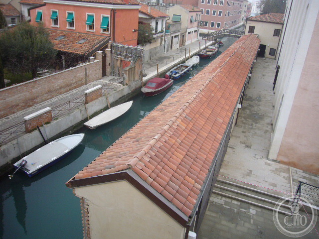 View over the tiled roof and canal beside the former convent, with moored boats