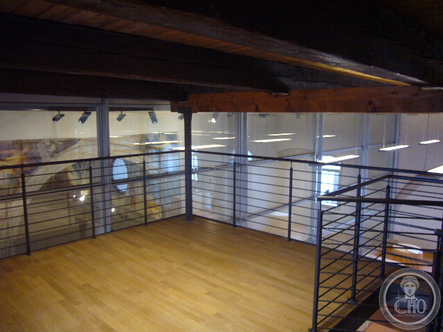 Timber mezzanine with iron railings under the roof beams of the former church