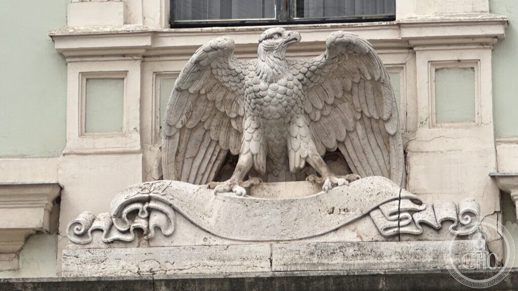 Close view of the carved stone eagle with spread wings standing on a blank scroll above the entrance