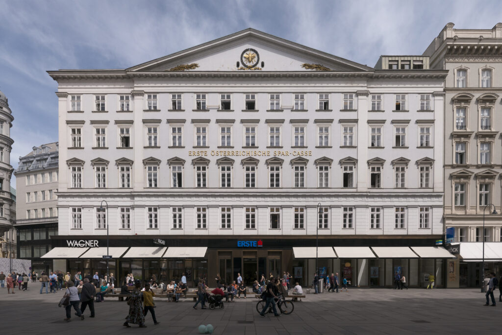 White late-classicist bank front on the Graben with a triangular pediment, a gilded bee in a wreath and the lettering ERSTE ÖSTERREICHISCHE SPAR-CASSE