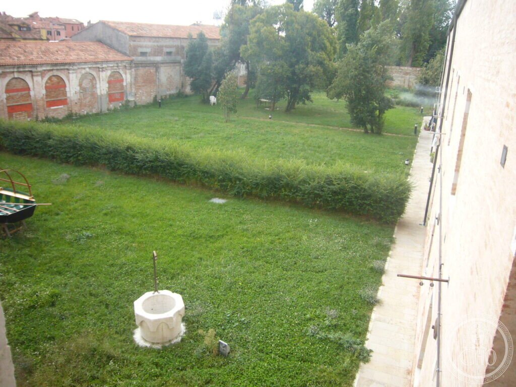 Walled garden of the former convent of Santi Cosma e Damiano seen from above, with well-head and lawns