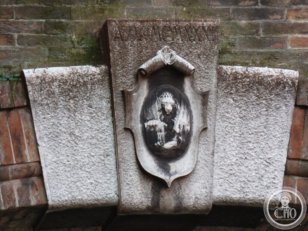 Carved stone shield with the date A.D. MCMXXXI and a relief of the winged lion of St Mark, on the bridge building of the former Manifattura Tabacchi, Venice