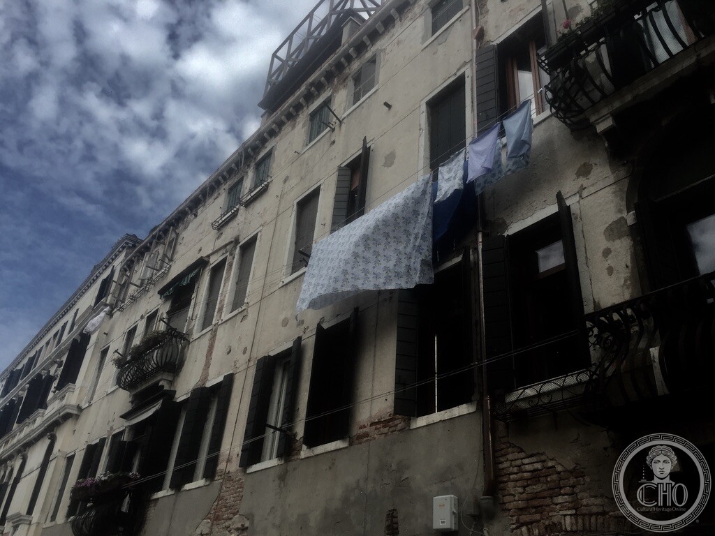 Looking up at the wooden altana roof terrace and ornate wrought-iron balconies on Fondamenta Rizzi in Santa Croce Venice