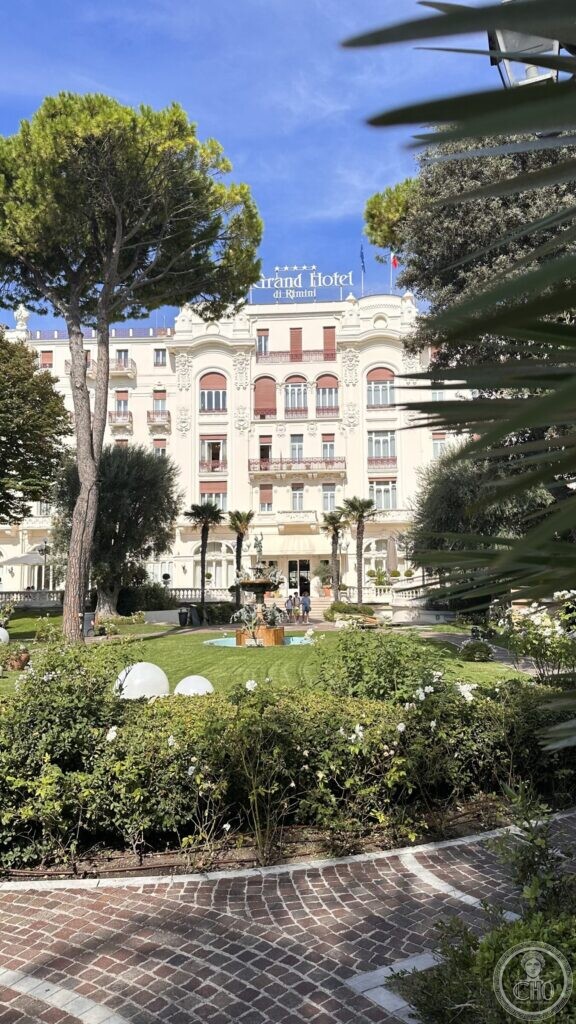 The Grand Hotel seen across its lawn, with pines and palms in the foreground