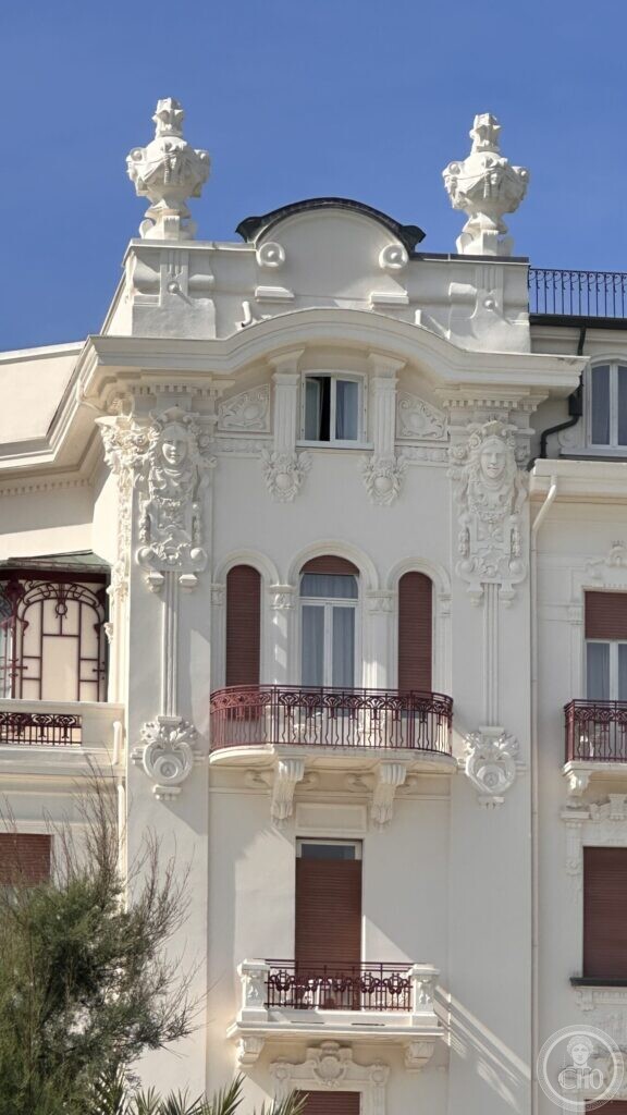 A projecting bay of the facade decorated with stucco garlands and topped by two carved urns