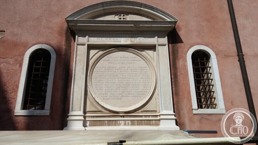 Marble war memorial plaque on the facade of the Chiesa di San Felice, Cannaregio, Venice, with a circular inscription listing the parish fallen of 1915-1918
