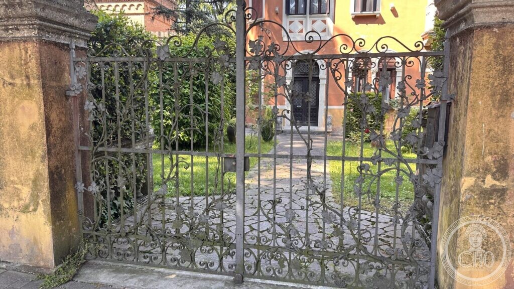 Detail of a wrought-iron gate worked into stems, leaves and open flowers