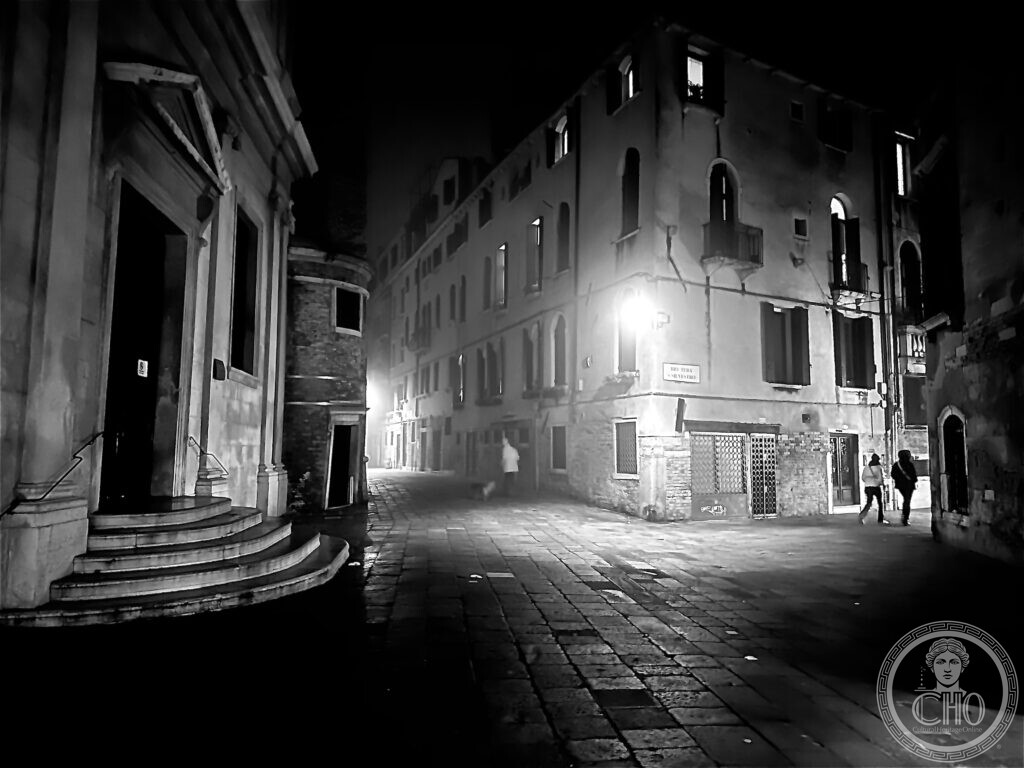 Rio Terà San Silvestro at night in black and white, the steps of the church of San Silvestro at the left and the street sign on the corner house
