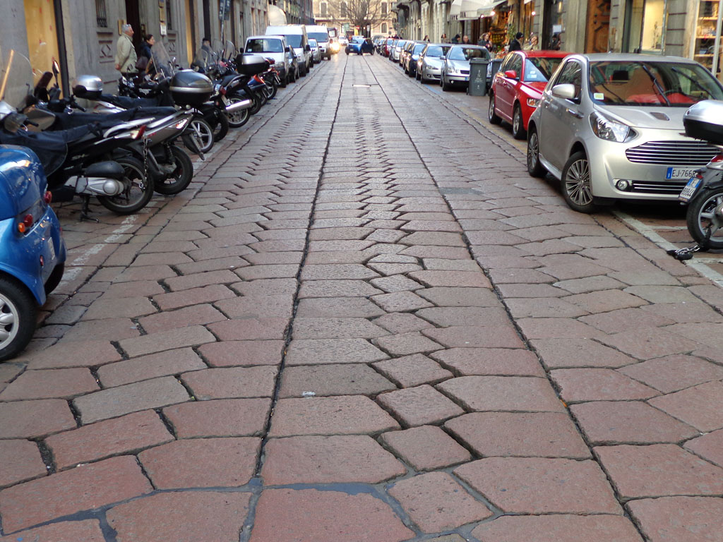 Stone cobbles and historic buildings along Via Solferino in Milan